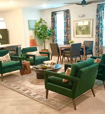 A living room with green chairs and a wooden coffee table.